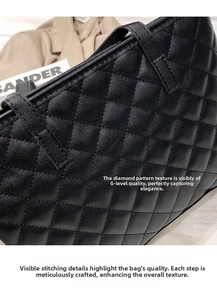Close-up detail of classic diamond quilted texture and neat stitching on black tote bag