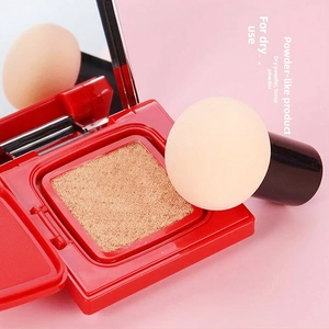Detail of red powder compact with mirror and mushroom head sponge for dry powder