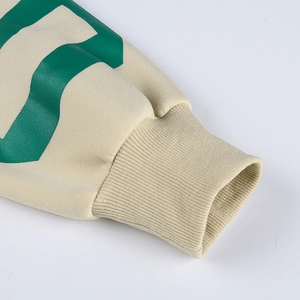 Gros plan du poignet d'un sweat beige avec impression graphique verte de qualité