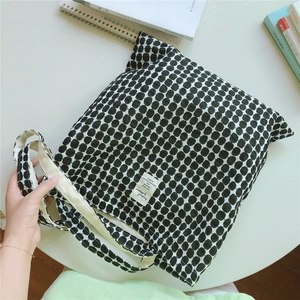 Detailed top view of a black polka dot canvas tote bag with stationery for daily use