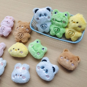 Assorted colorful plush animal heads and mini figures on a wooden surface
