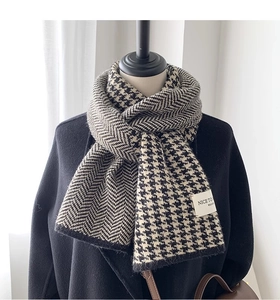 Detail of knitted houndstooth and herringbone pattern scarf with soft texture