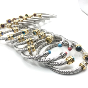 Macro shot of twisted cable bracelets with colorful gemstones and golden end caps
