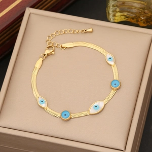 Golden snake chain bracelet featuring blue devil eye charm on a jewelry box
