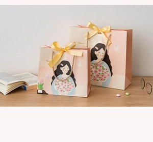 Close-up of pink teacher gift bags with golden bow and Thank You Teacher text