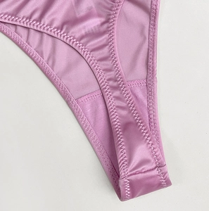 Detailed macro view of reinforced zigzag stitching on pink satin thong inner crotch