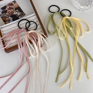 Detail of colorful silk satin ribbon hair ties in pastel pink green and beige hues