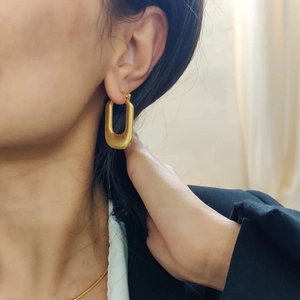 Elegant 18K gold-plated U-shaped stainless steel earrings on a model’s ear