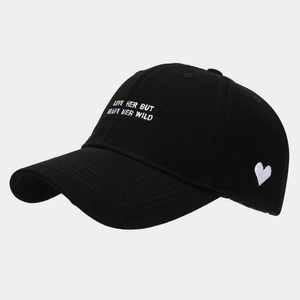 Close-up of black cotton baseball cap with white heart embroidery and side text detail