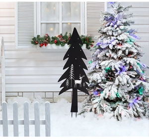 Detail of black metal Christmas silhouette stakes with reindeer and trees in snowy garden