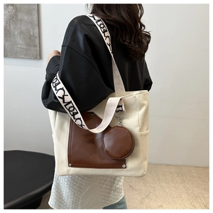 Detail of canvas tote bag with brown leather pocket and round coin purse hanging