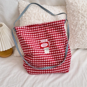 Close-up of red gingham wool tote bag with cherry patch and white ribbon detail