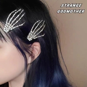 Barrettes main de squelette avec strass portées sur les cheveux bleus d'un modèle