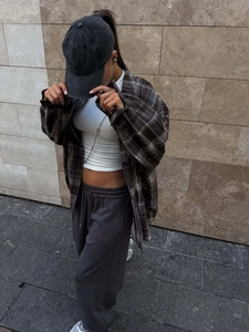 Women's plaid button-down shirt paired with grey joggers for a retro street fashion style