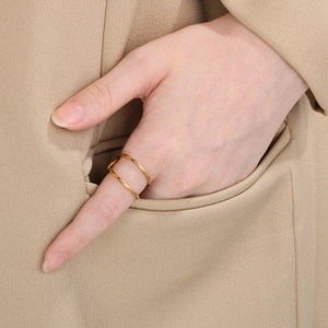 Detail of minimalist double-layered gold stainless steel ring worn on model hand