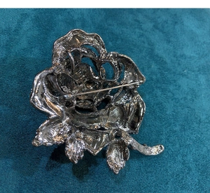 Detail view of the vintage rose brooch back featuring a secure rotating safety pin lock