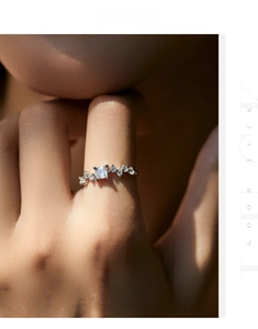 Macro detail of silver ring with emerald-cut zirconia and wavy pavé diamond accents