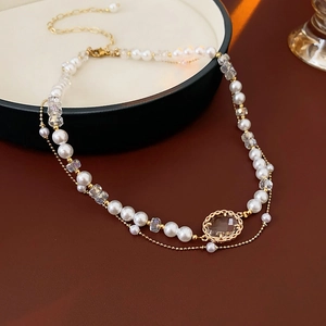 Detail showing double-layer pearl necklace with an oval crystal pendant in gold frame