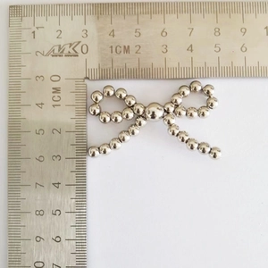 Detailed size measurement of silver pearl bow accessory showing width of 5cm on white background