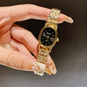 Elegant women's quartz watch with a gold steel band and oval black dial by Dinimi