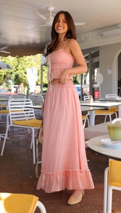 Detail of pink summer set featuring drawstring bow top and flowing tiered maxi skirt