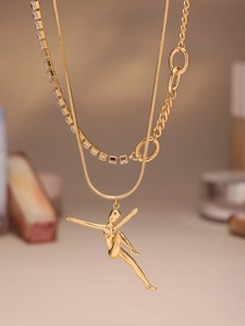 Detail of layered gold necklace with dancing girl pendant, snake and tennis chains