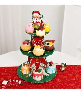 Three-tier Christmas paper cupcake stand with Santa and snowman patterns on festive table