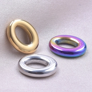 Close-up of oval stainless steel 18k plated pendants in gold, silver, and iridescent colors