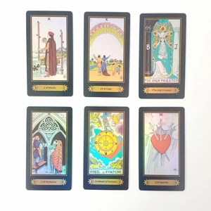 Detailed macro view of black laser tarot cards featuring gold foil mystical illustrations