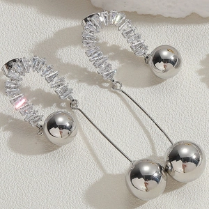 Vue macro détaillée de boucles d'oreilles en argent en U avec zircon et sphères polies