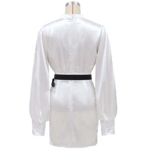 Détail de robe longue satinée blanche avec fermeture éclair au dos et ceinture noire
