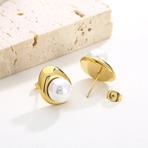 Macro shot of 18K gold plated C-shaped earrings with large white pearls and zircons