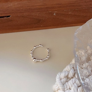 Macro detail of 925 sterling silver beaded open ring with layered spheres and mirror finish