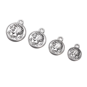 Macro view of four antique silver coin pendants in varying sizes with portrait reliefs