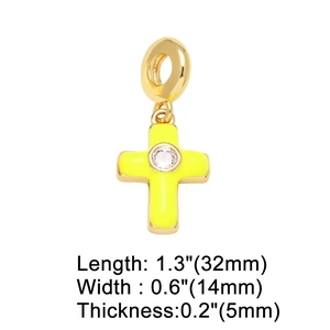 Macro detail of gold cross pendant with fluorescent yellow enamel and cubic zirconia