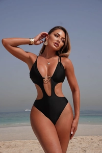Detail of sexy cutout swimsuit featuring a golden heart-shaped metal buckle on the waist