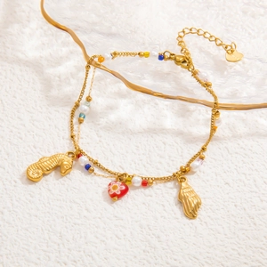 Close-up of double-layer gold chain with seahorse, heart, and pearl seashell charms