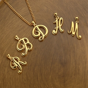 Minimalist 18K gold plated stainless steel cursive letter pendants on a wooden disc