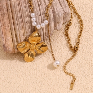 Detail of 18K gold-plated flower pendant necklace with elegant white pearl accents