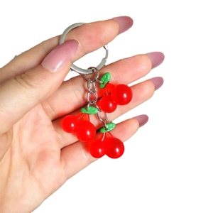 Luminous cherry keychain with red resin fruit and green leaves on a silver keyring