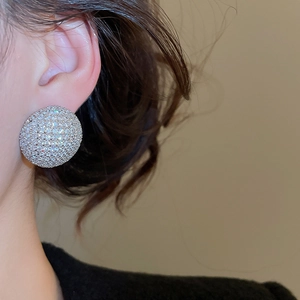 Gros plan d'une boucle d'oreille dôme en argent avec pavé de zircons brillants