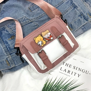 Detail of pink and white nylon messenger bag with cute cartoon patches on denim