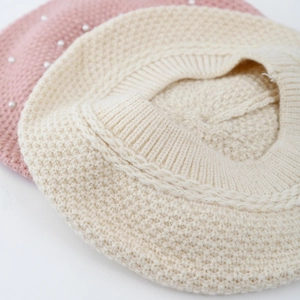 Detail of waffle knit beret for girls with elegant pearl accents and ribbed edges
