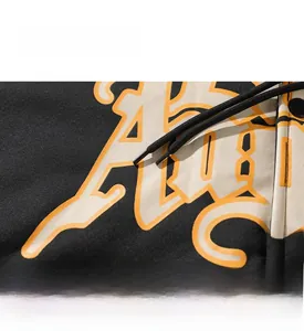 Detail view of premium black hoodie with cylindrical drawstring and streetwear graphic print