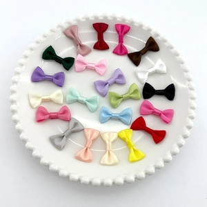 Close-up of colorful mini polyester ribbon bows neatly arranged in a white ceramic dish