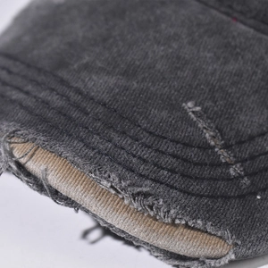 Macro shot of vintage washed gray baseball cap featuring distressed torn brim details