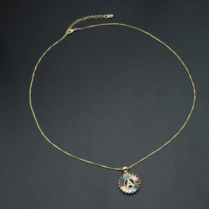 Close-up of gold 26-letter A pendant featuring multi-color sunburst crystal setting