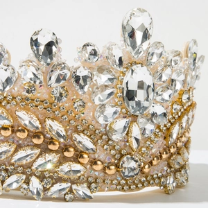 Close-up of golden baroque tiara with pear-cut crystals and intricate rhinestone details