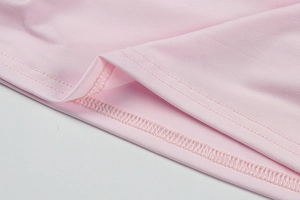 Détail macro de la texture du tissu de la robe rose avec couture professionnelle à double aiguille