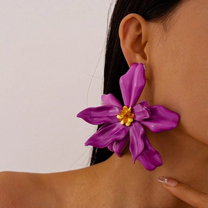 Close-up of oversized purple acrylic flower earring with yellow beaded stamen on model